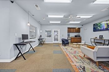A living room with a white couch, a black table, and a rug with a colorful design at Peachtree Place Apartments, Columbia 29210